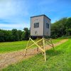 Elevated Hunting Blind on Sturdy Wooden Legs in Green Field