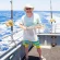 Man Holding Fish on a Boat with Ocean in Background